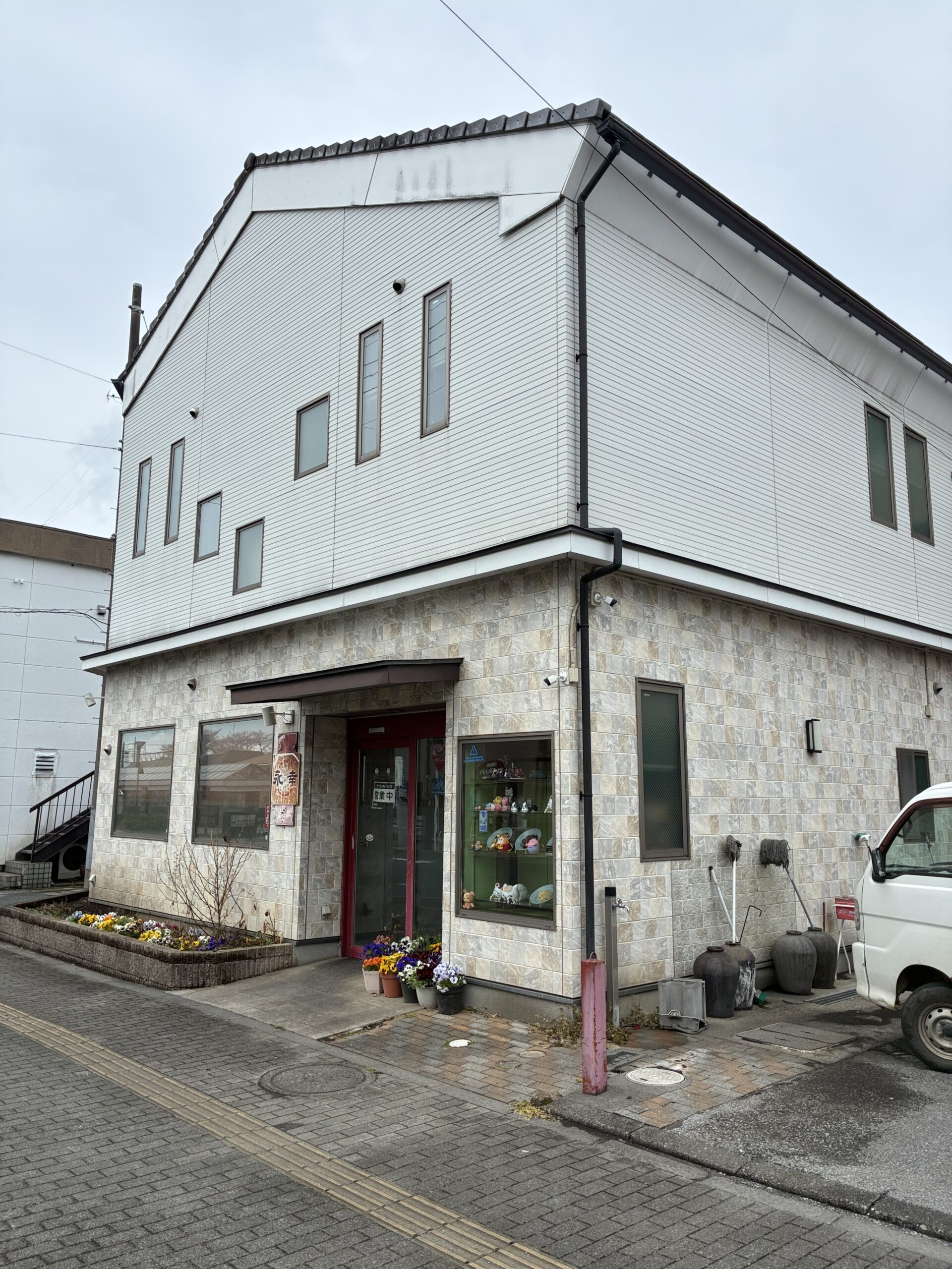 白い壁と石垣風の壁が特徴的な永幸の外観