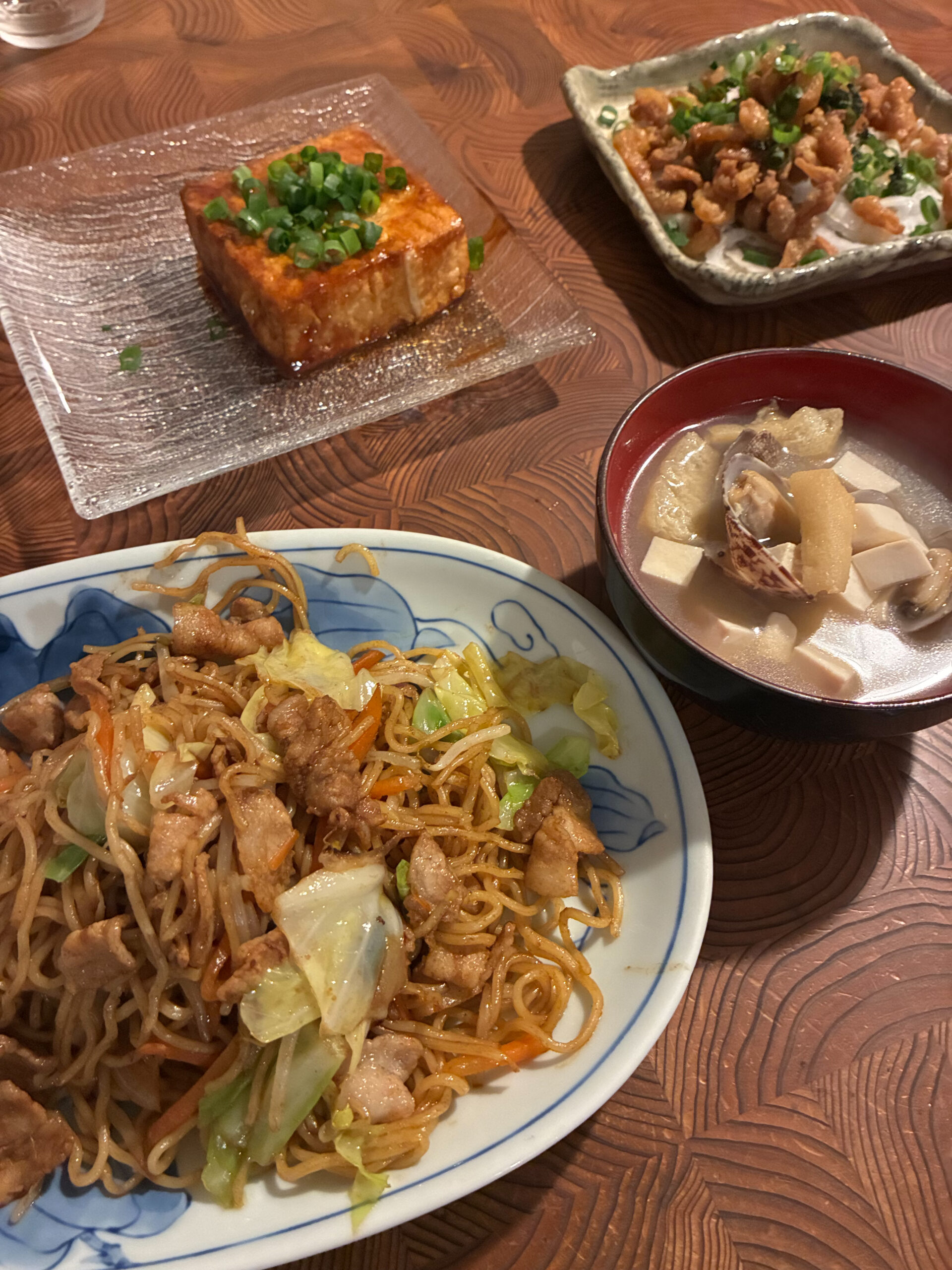 テーブルに並んだ手作り和食。ソース焼きそば、厚揚げの煮付け、あさりのお椀、鶏皮の和え物。