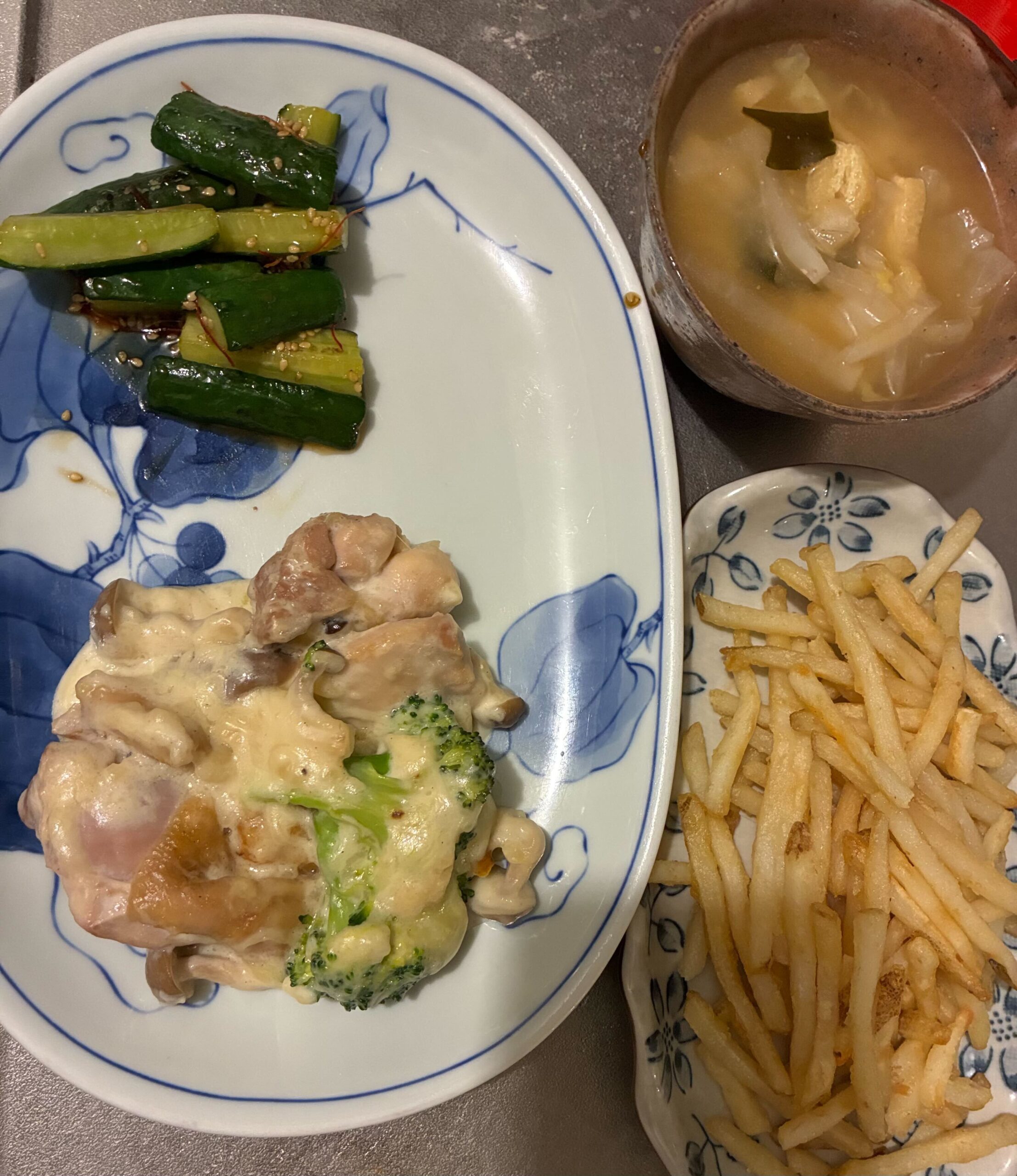 鶏肉とブロッコリーのクリーム煮、たたききゅうり、フライドポテト、お味噌汁が並んだ食卓