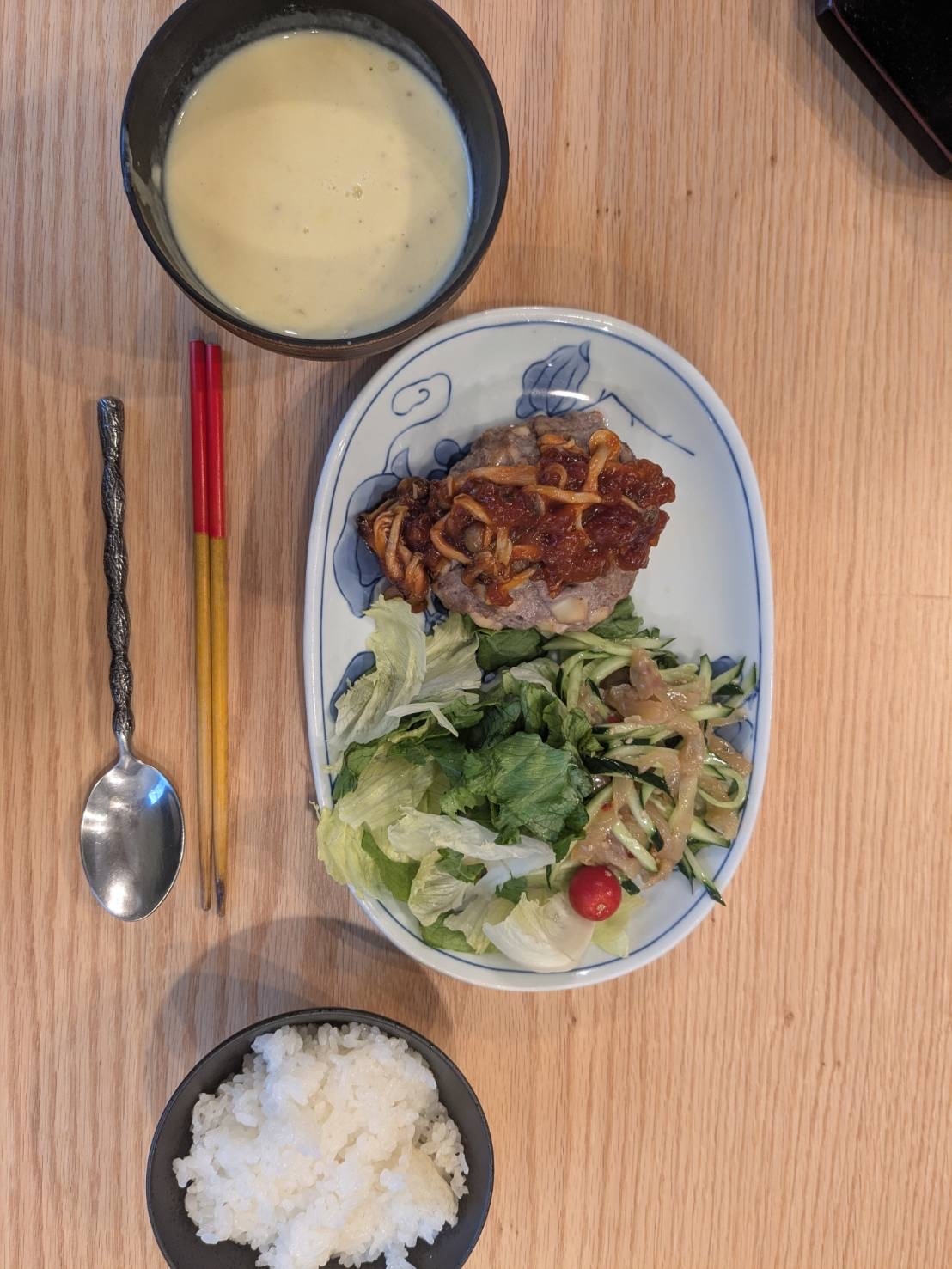 和風ハンバーグランチの定食。きのこの和風ソースがかかったハンバーグ、サラダ、ごはん、スープが並んでいる。