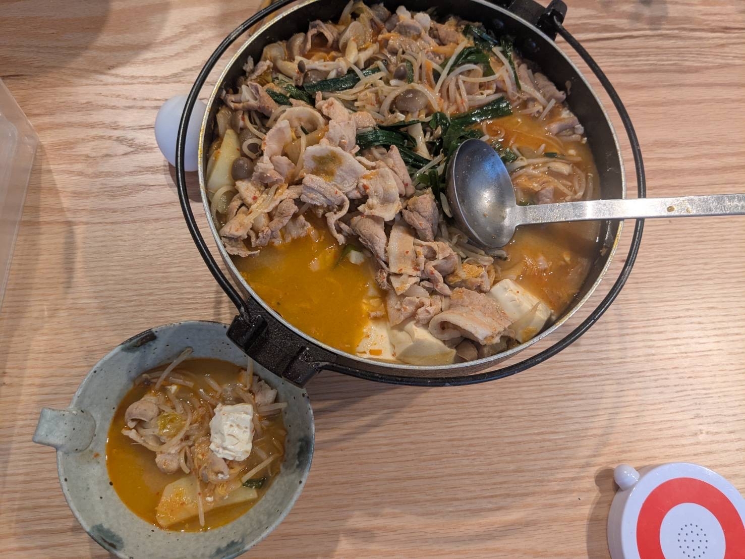 具沢山で温かいピリ辛豚肉鍋が黒い鍋で煮えている様子