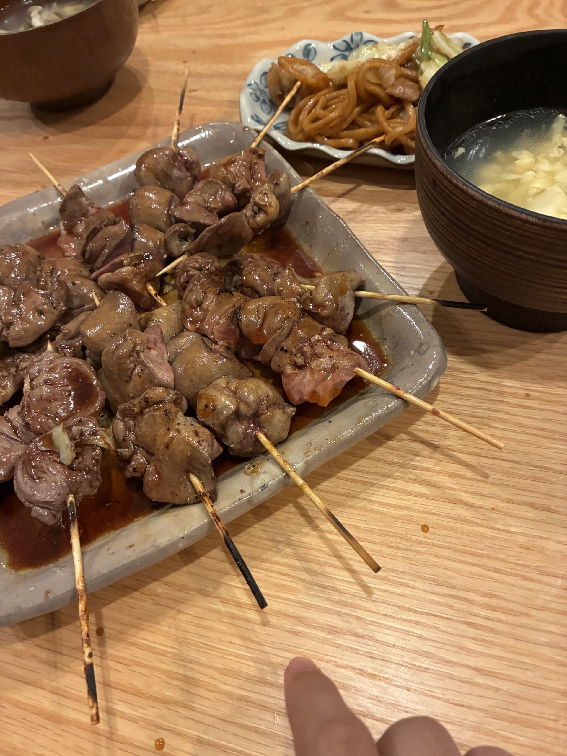 木製のテーブルに置かれた、照りのあるレバー串の盛り合わせ