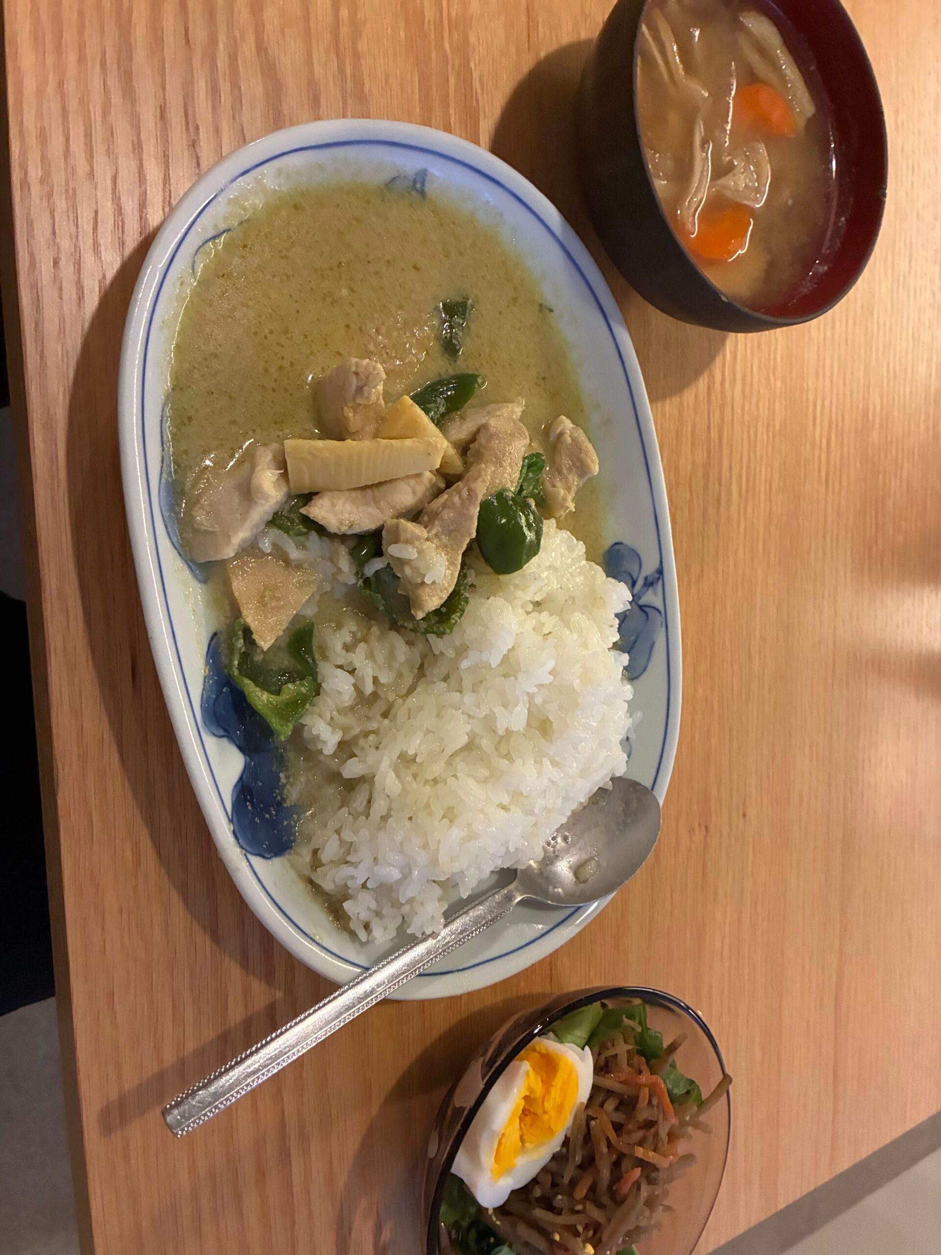 食卓に並んだ手作りのグリーンカレーと味噌汁、きんぴらごぼうの小鉢